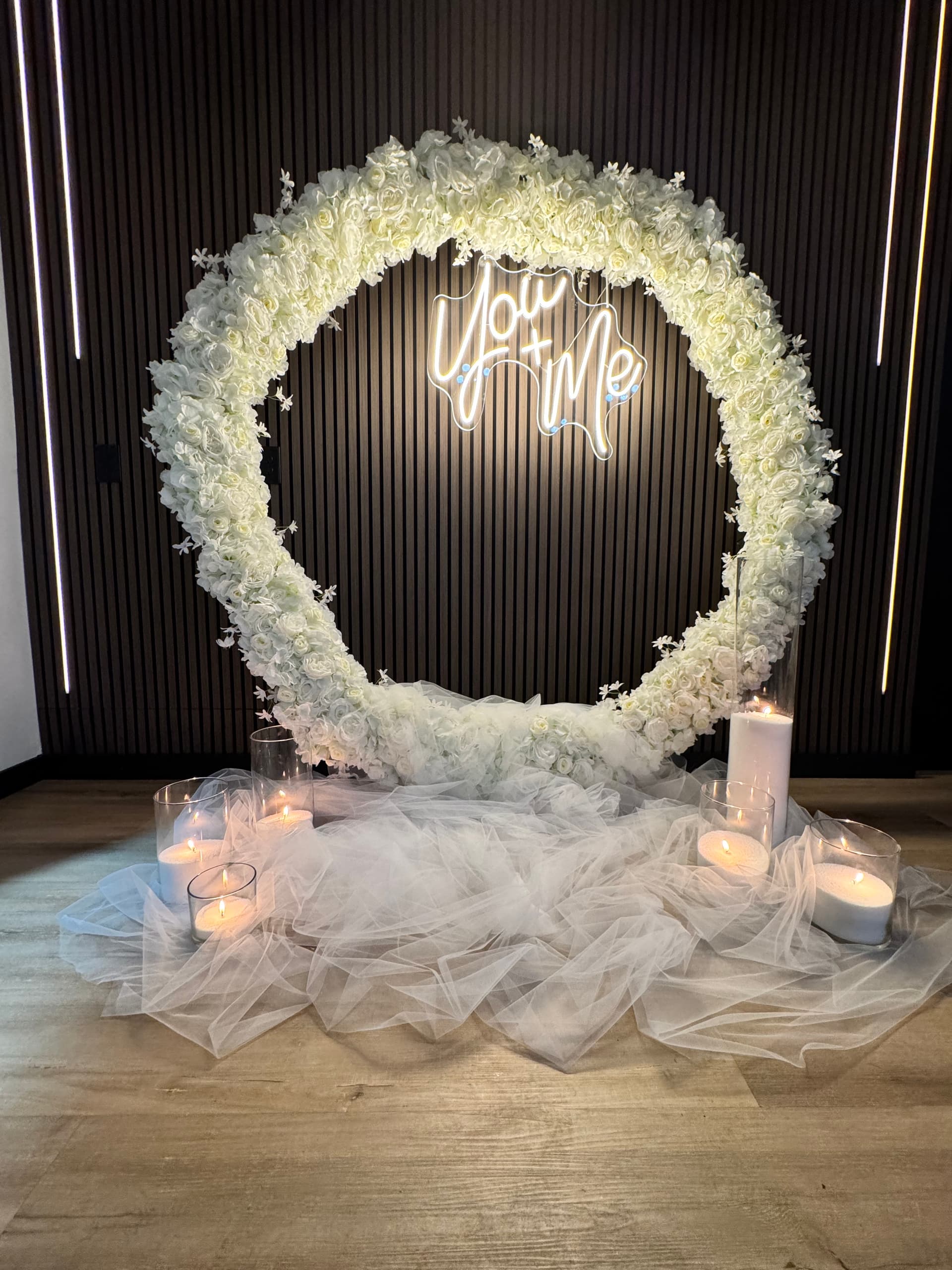White floral installation with a glowing wedding sign at Altar'd Event Venue
